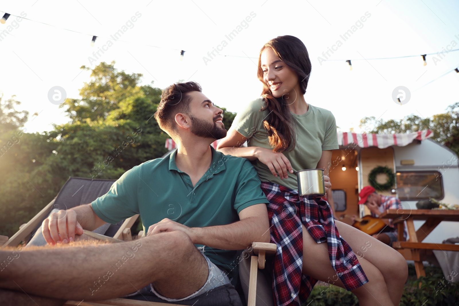 Photo of Happy friends resting near motorhome. Camping season