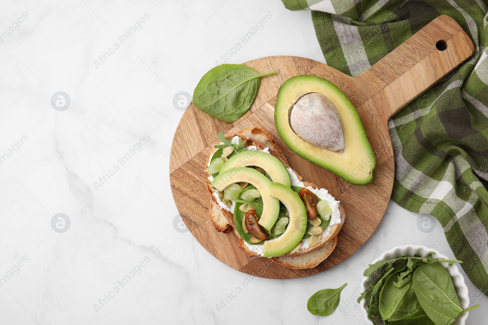 Photo of Tasty vegan sandwich with avocado, tomato and spinach on white marble table, flat lay. Space for text