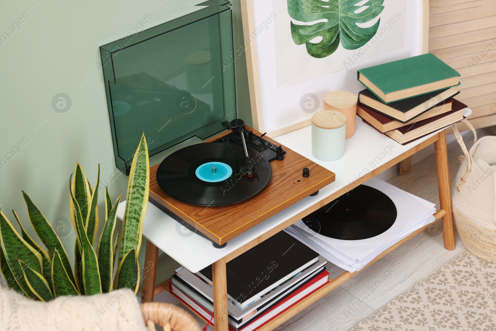 Photo of Stylish turntable with vinyl record console table in room