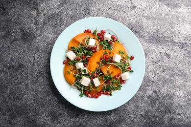Photo of Delicious persimmon salad served on grey table, top view