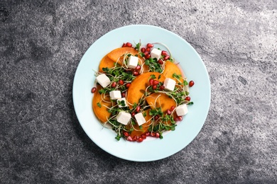 Delicious persimmon salad served on grey table, top view