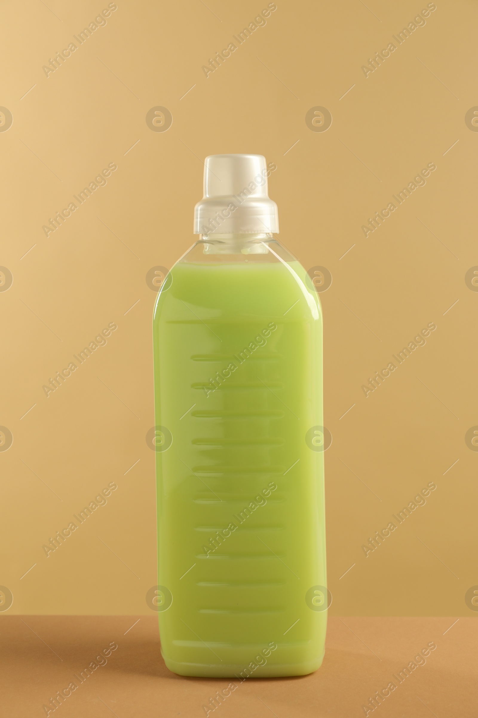 Photo of Bottle with detergent on beige background. Cleaning supply