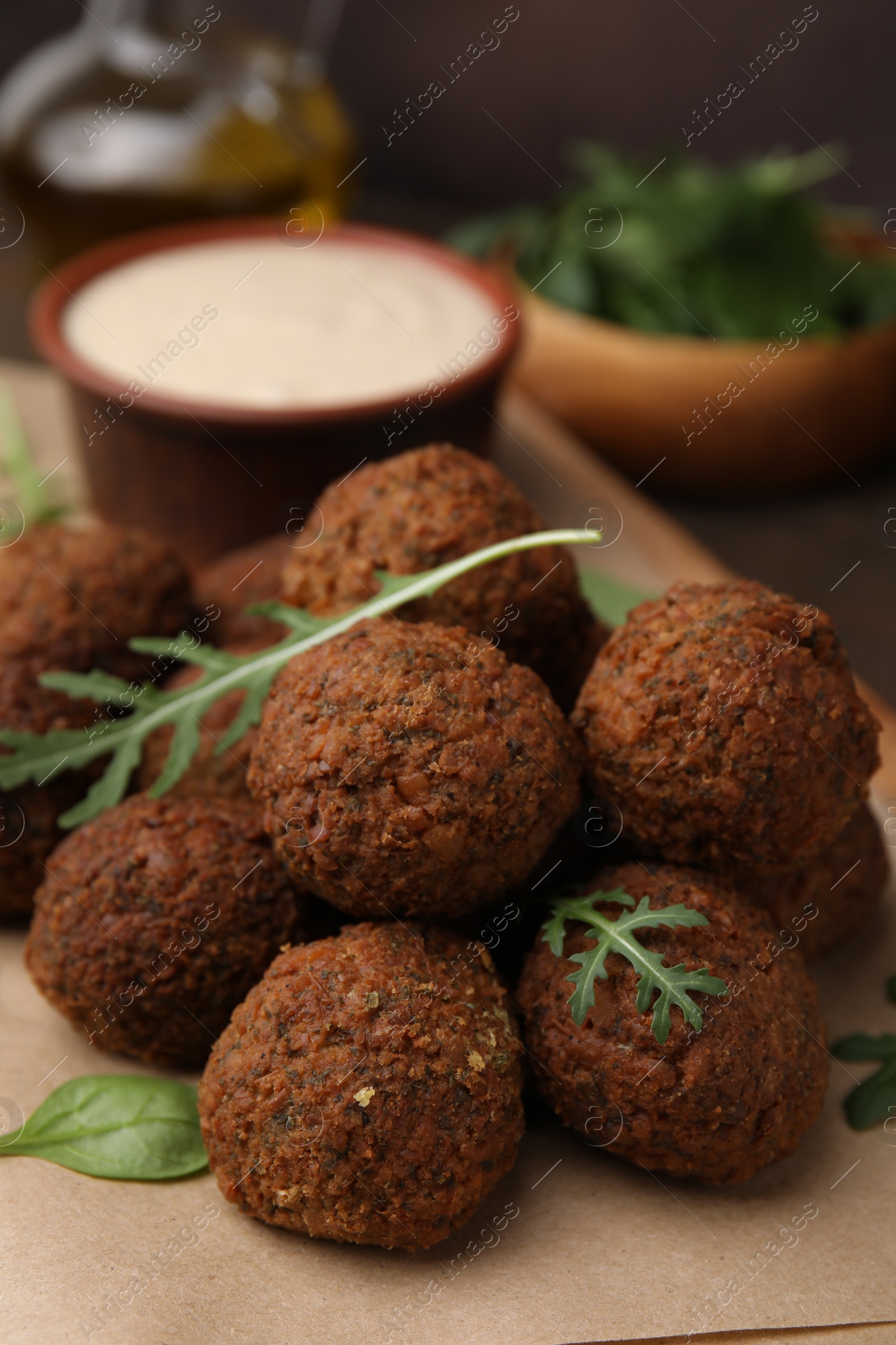 Photo of Delicious falafel balls and arugula on table