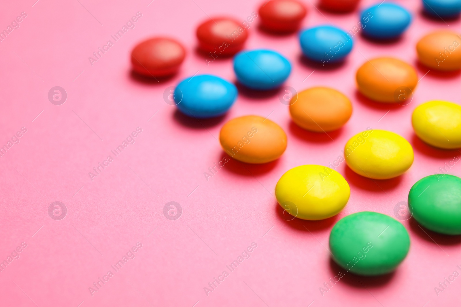 Photo of Tasty glazed candies on color background, closeup. Space for text