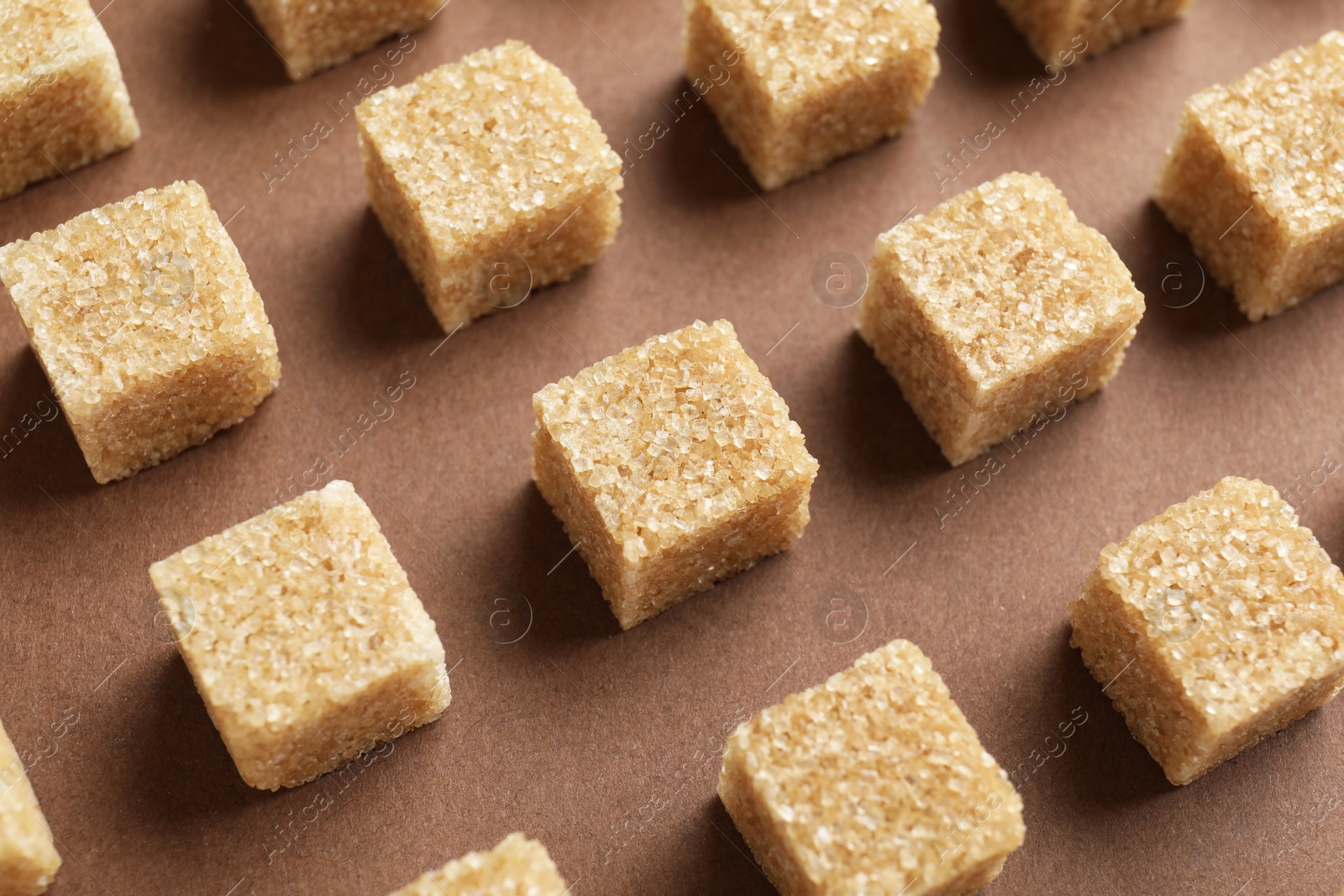 Photo of Brown sugar cubes on color background, above view