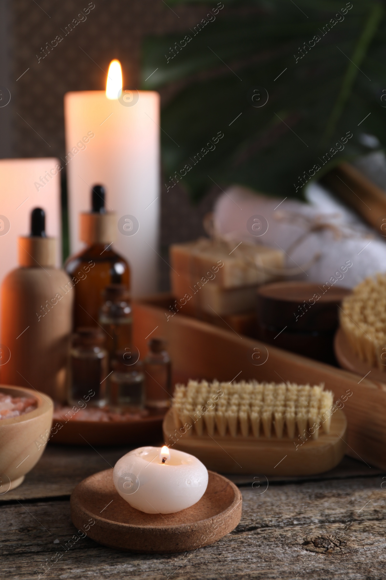Photo of Composition with different spa products and burning candles on wooden table