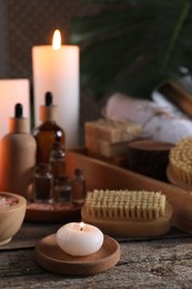 Photo of Composition with different spa products and burning candles on wooden table