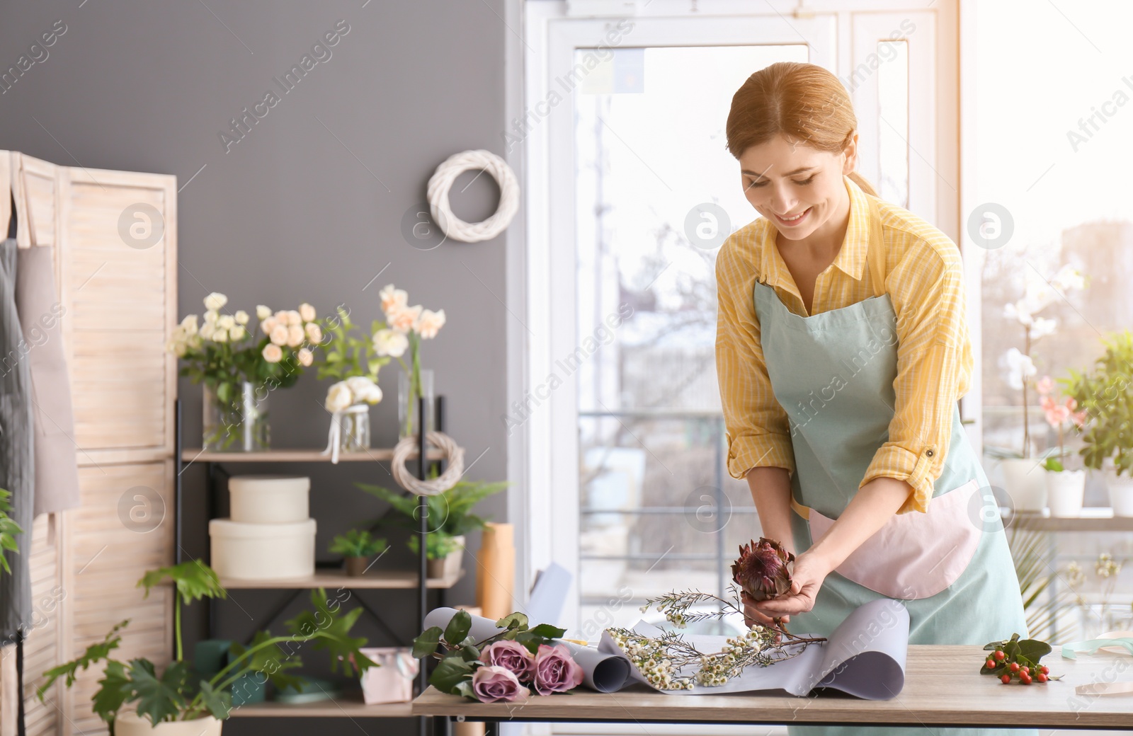 Photo of Female florist creating bouquet at workplace