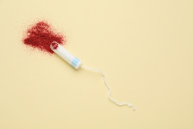 Photo of Tampon with red glitter on beige background, flat lay and space for text. Menstrual hygiene product