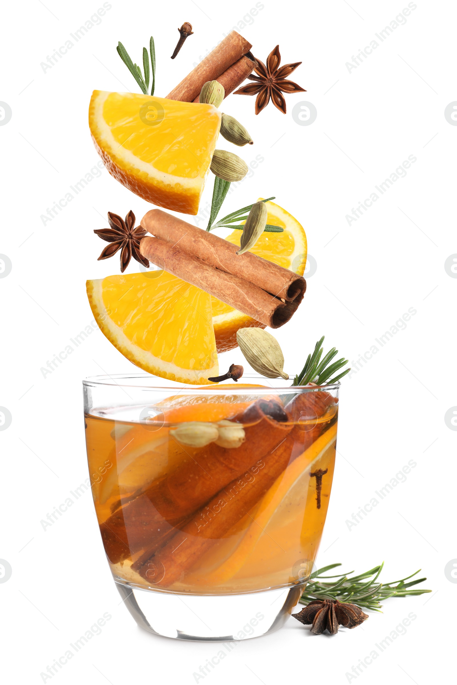 Image of Cut orange and different spices falling into glass of mulled wine on white background 