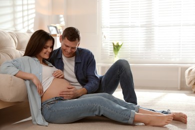 Young pregnant woman with her husband at home