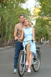 Happy couple with bicycle outdoors on summer day