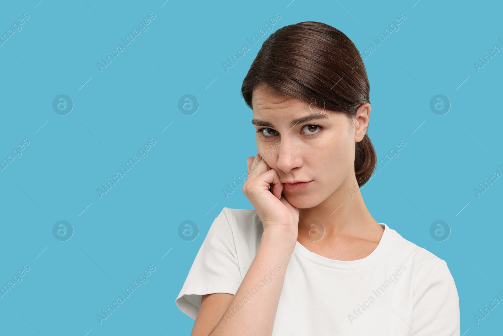 Photo of Portrait of resentful woman on light blue background, space for text