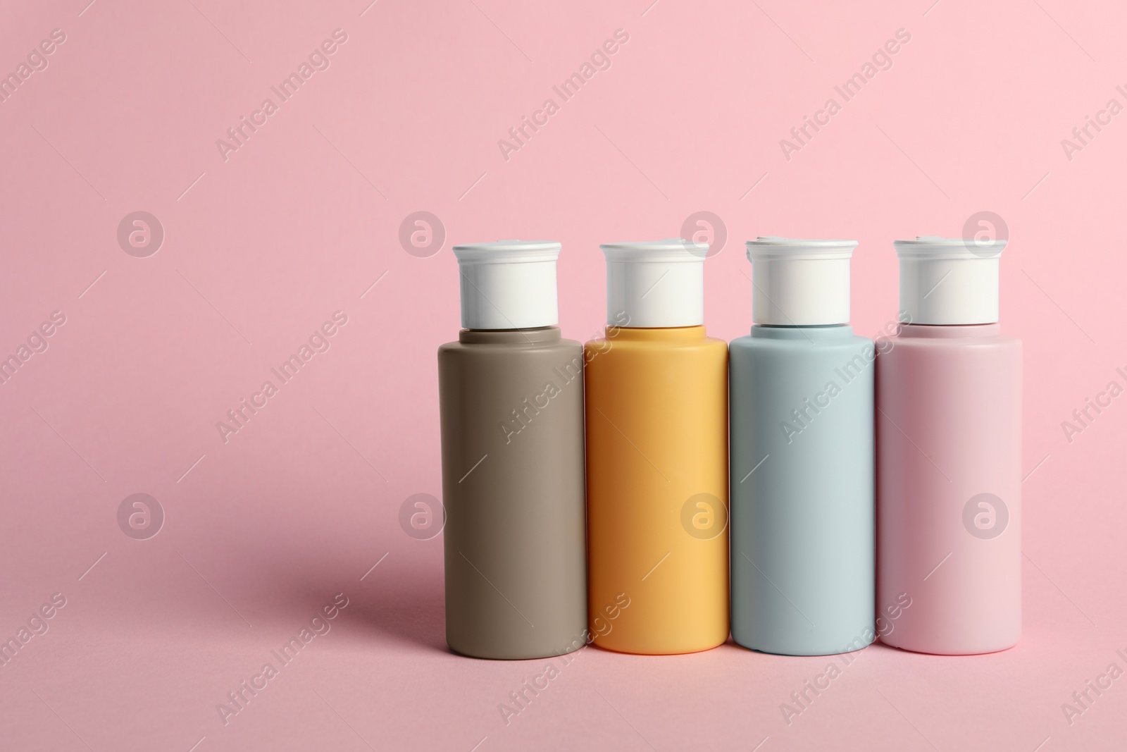 Photo of Cosmetic travel on pink background. Space for text