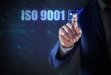 Man pointing at virtual screen with text ISO 9001, closeup