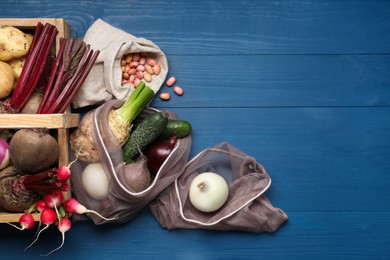 Different fresh ripe vegetables on blue wooden table, flat lay. Space for text