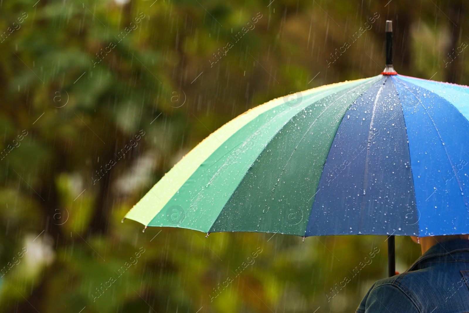 Photo of Person with bright umbrella under rain on street, closeup