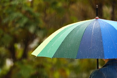 Photo of Person with bright umbrella under rain on street, closeup