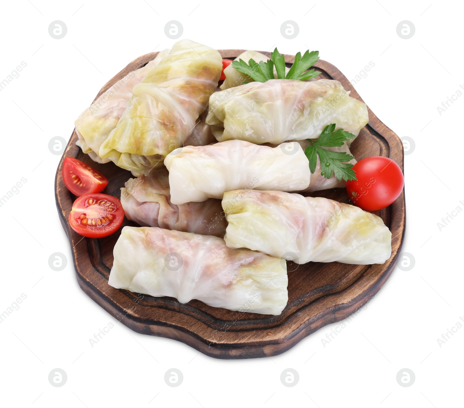 Photo of Wooden board with uncooked stuffed cabbage rolls, tomatoes and parsley isolated on white