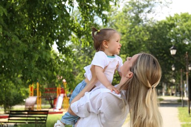 Photo of Mother with her daughter spending time together in park. Space for text