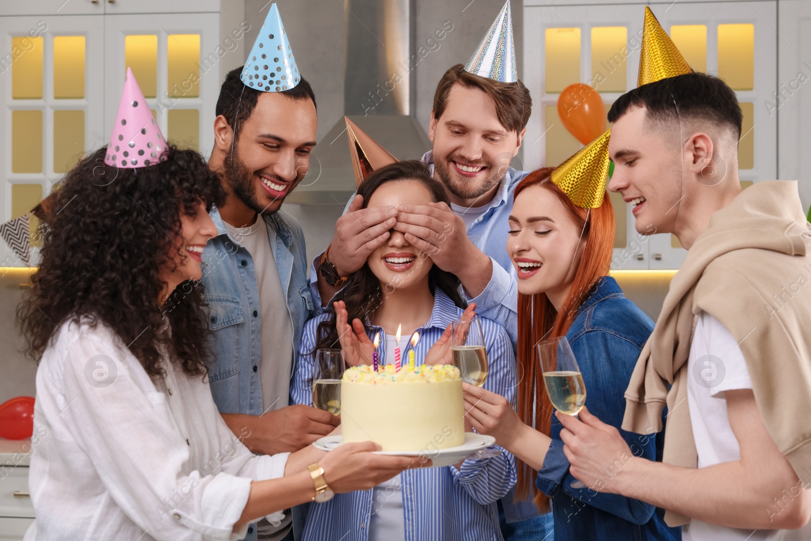 Photo of Happy friends with tasty cake celebrating birthday indoors