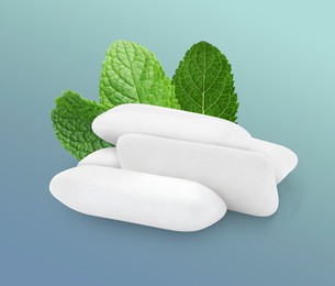 Image of Menthol chewing gum pillows and mint leaves on greyish blue background