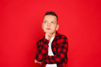 Photo of Portrait of cute little boy on red background