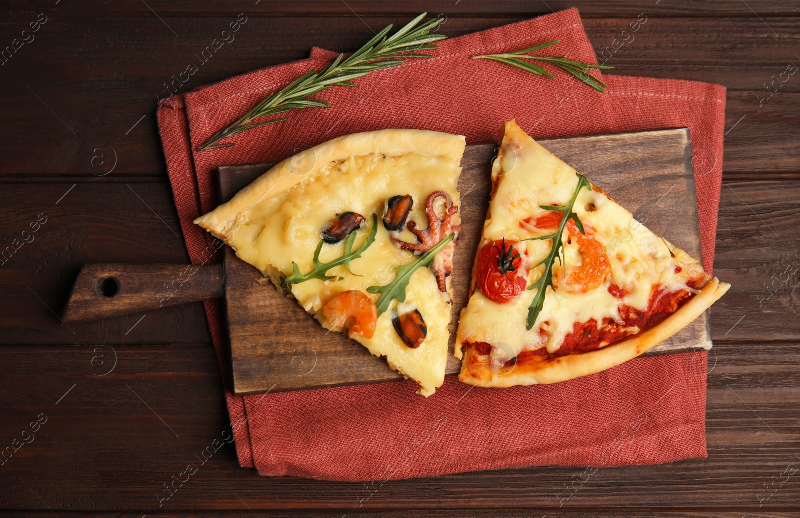 Photo of Pieces of delicious seafood pizza on wooden table, flat lay