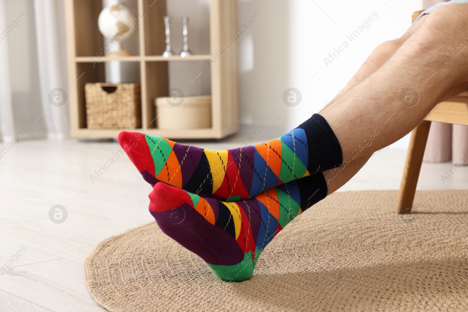 Photo of Man in stylish colorful socks indoors, closeup