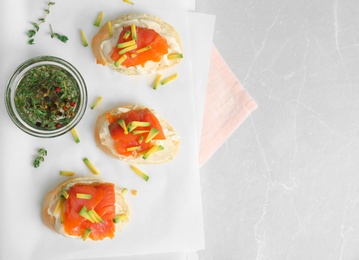 Photo of Sandwiches with fresh sliced salmon fillet and avocado on table