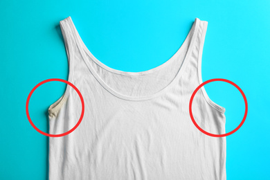 Undershirt before and after using deodorant on light blue background, top view