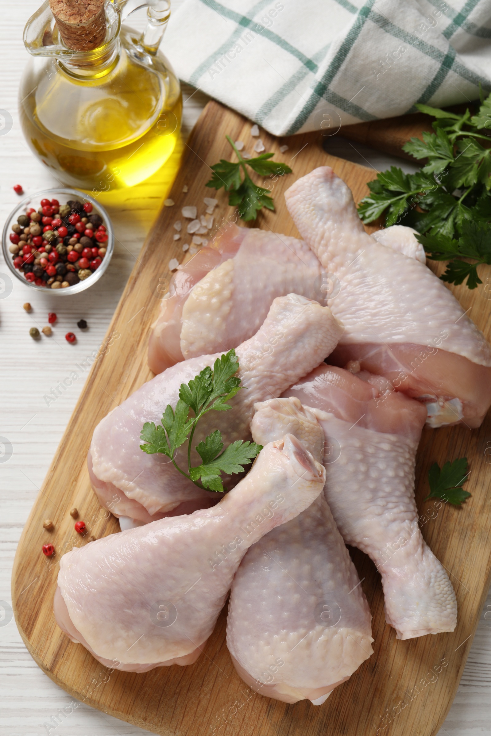Photo of Raw chicken drumsticks and ingredients on white wooden table, flat lay