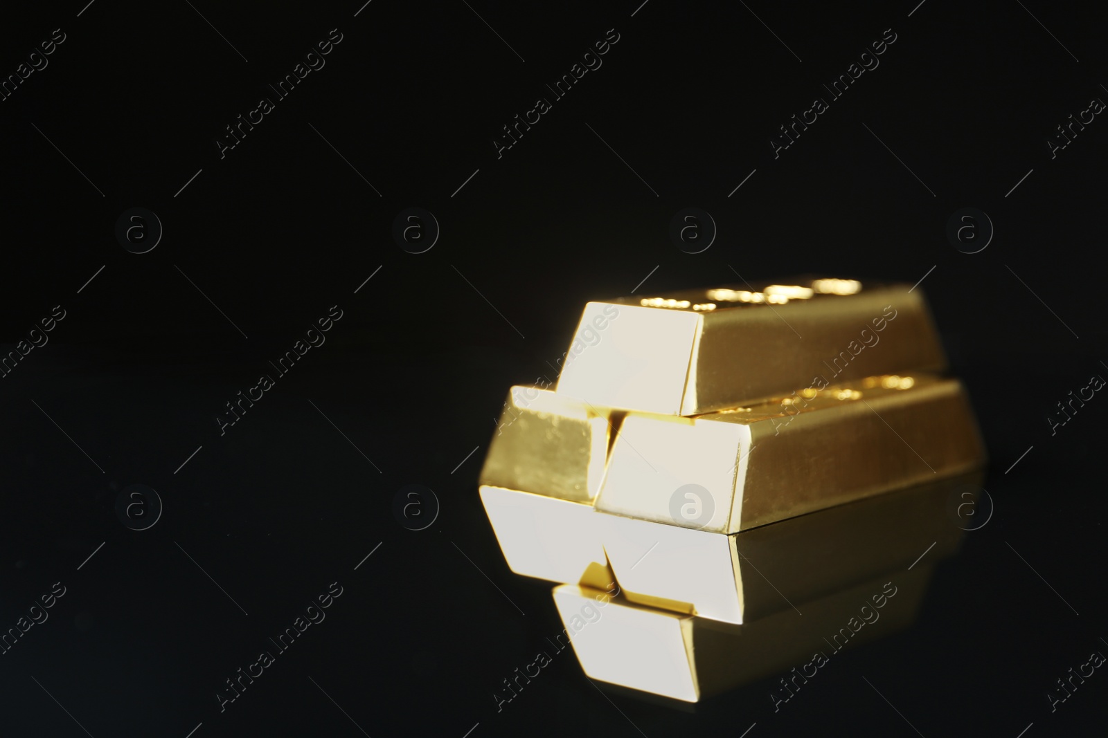 Photo of Shiny gold bars on black background. Space for text