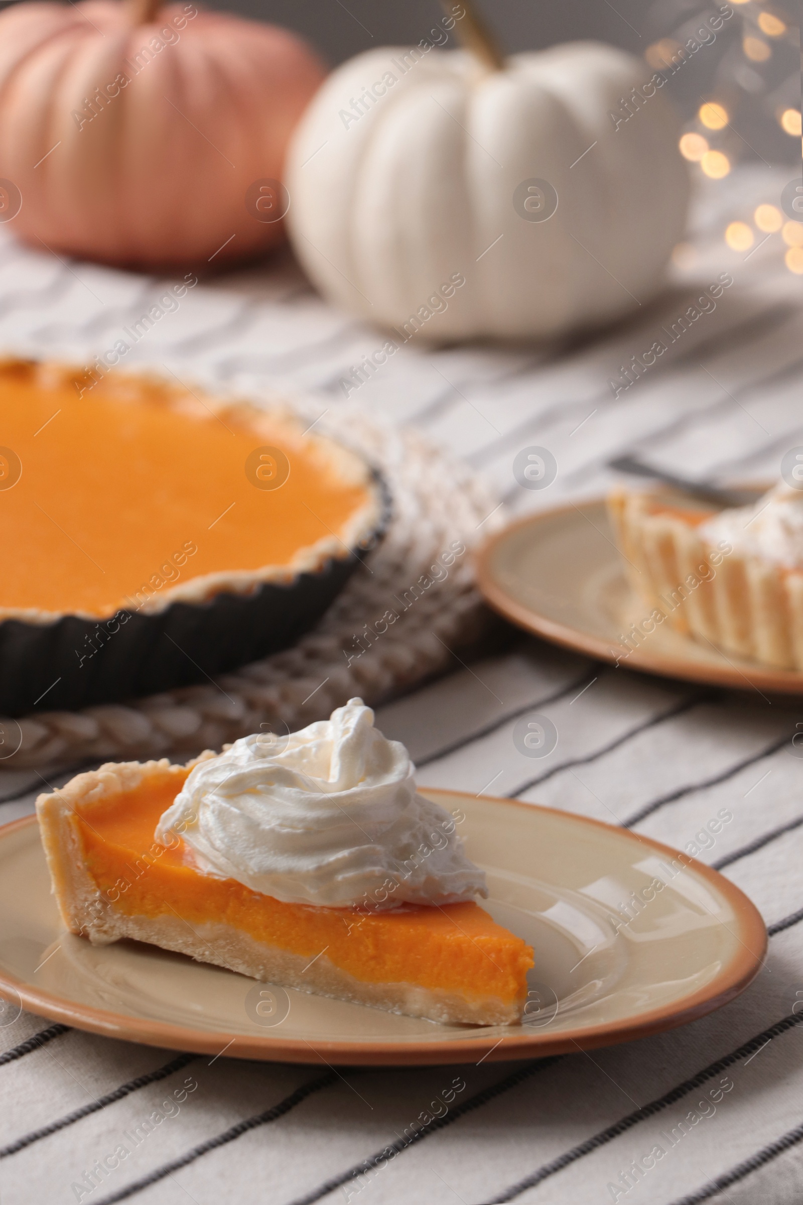 Photo of Piece of fresh homemade pumpkin pie with whipped cream on table