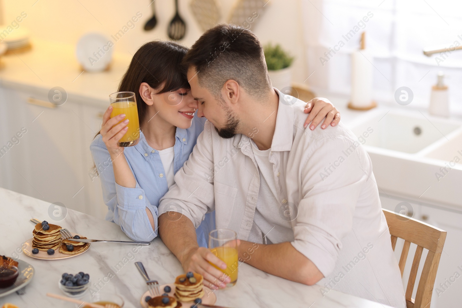 Photo of Happy couple spending time together during breakfast at home