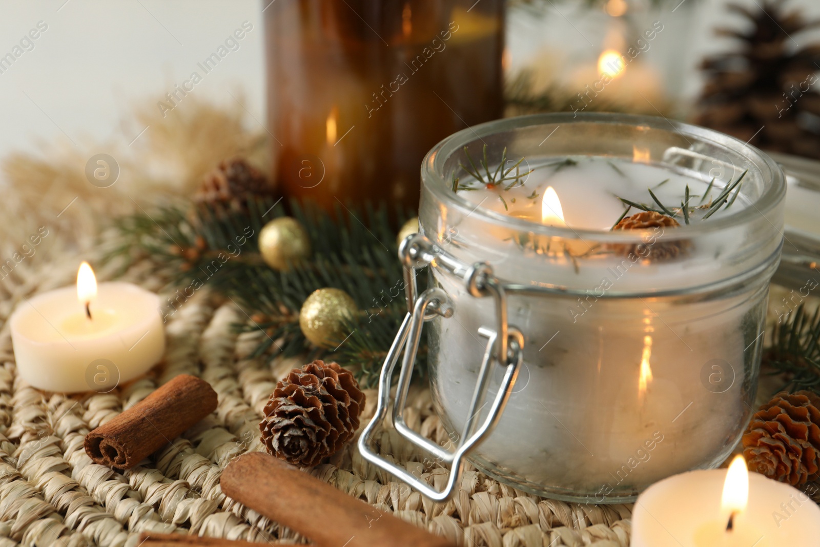 Photo of Burning scented conifer candles and Christmas decor on table. Space for text