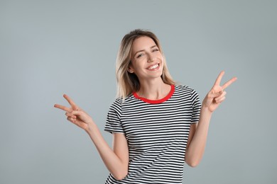 Photo of Woman showing number four with her hands on light grey background