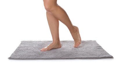 Photo of Woman standing on soft grey bath mat against white background, closeup