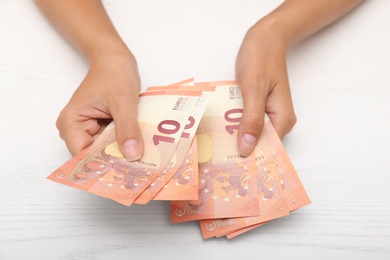 Photo of Woman with Euro banknotes at table, closeup