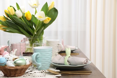 Festive table setting with beautiful flowers, space for text. Easter celebration