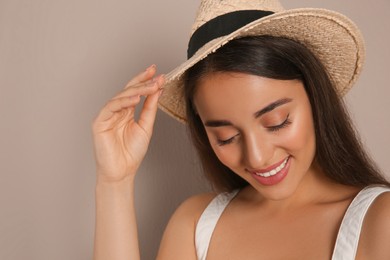 Photo of Beautiful young woman wearing straw hat on beige background. Stylish headdress