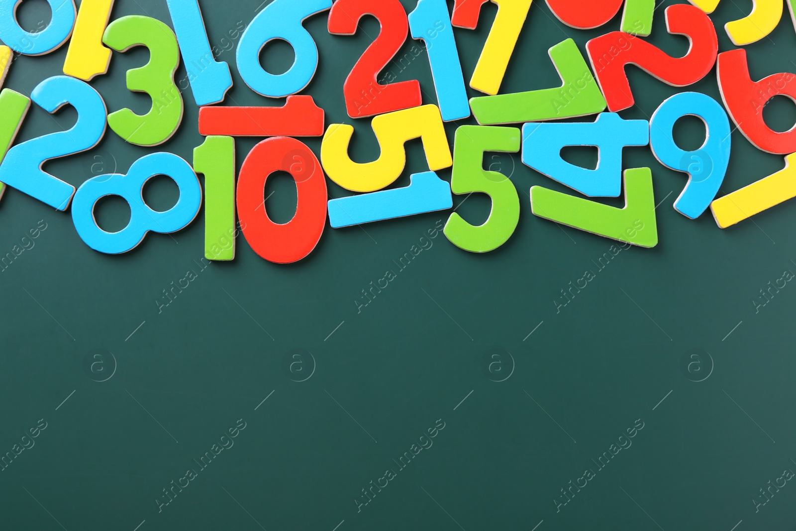 Photo of Colorful numbers on green background, flat lay. Space for text