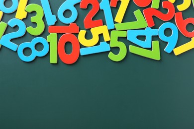 Photo of Colorful numbers on green background, flat lay. Space for text