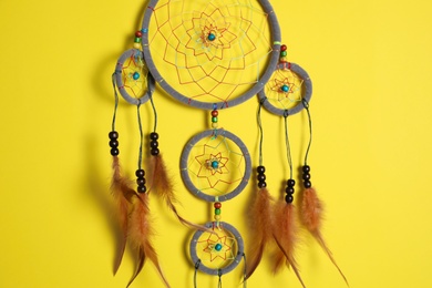 Beautiful dream catcher hanging on yellow background