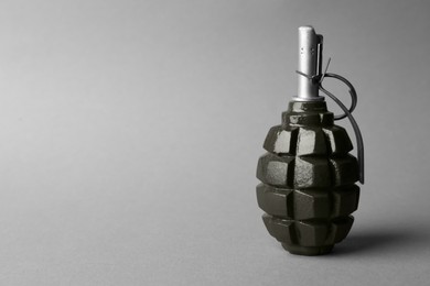 Photo of Hand grenade on grey background. Space for text