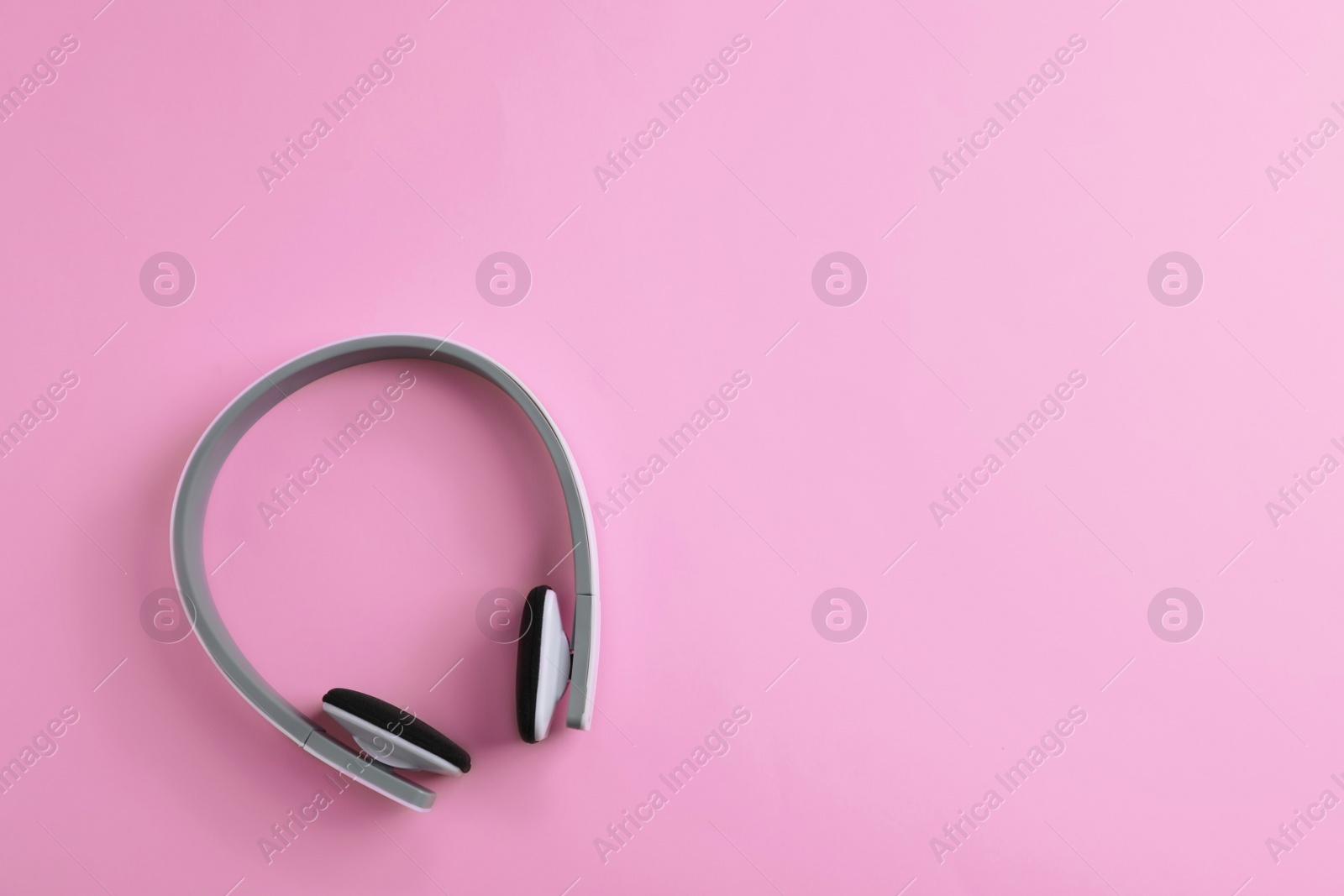 Photo of Wireless headphones on color background, top view. Space for text