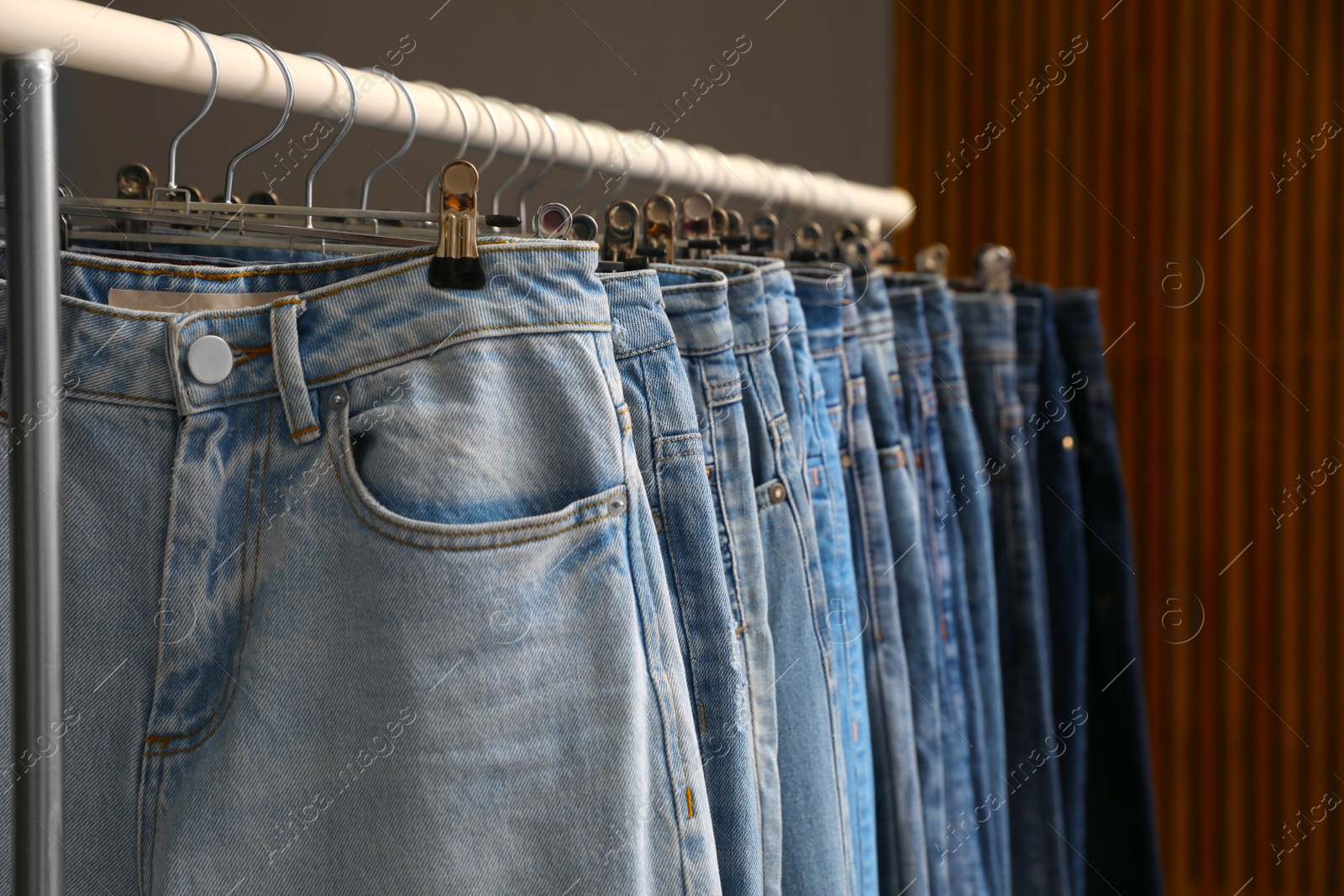 Photo of Rack with different stylish jeans, closeup view