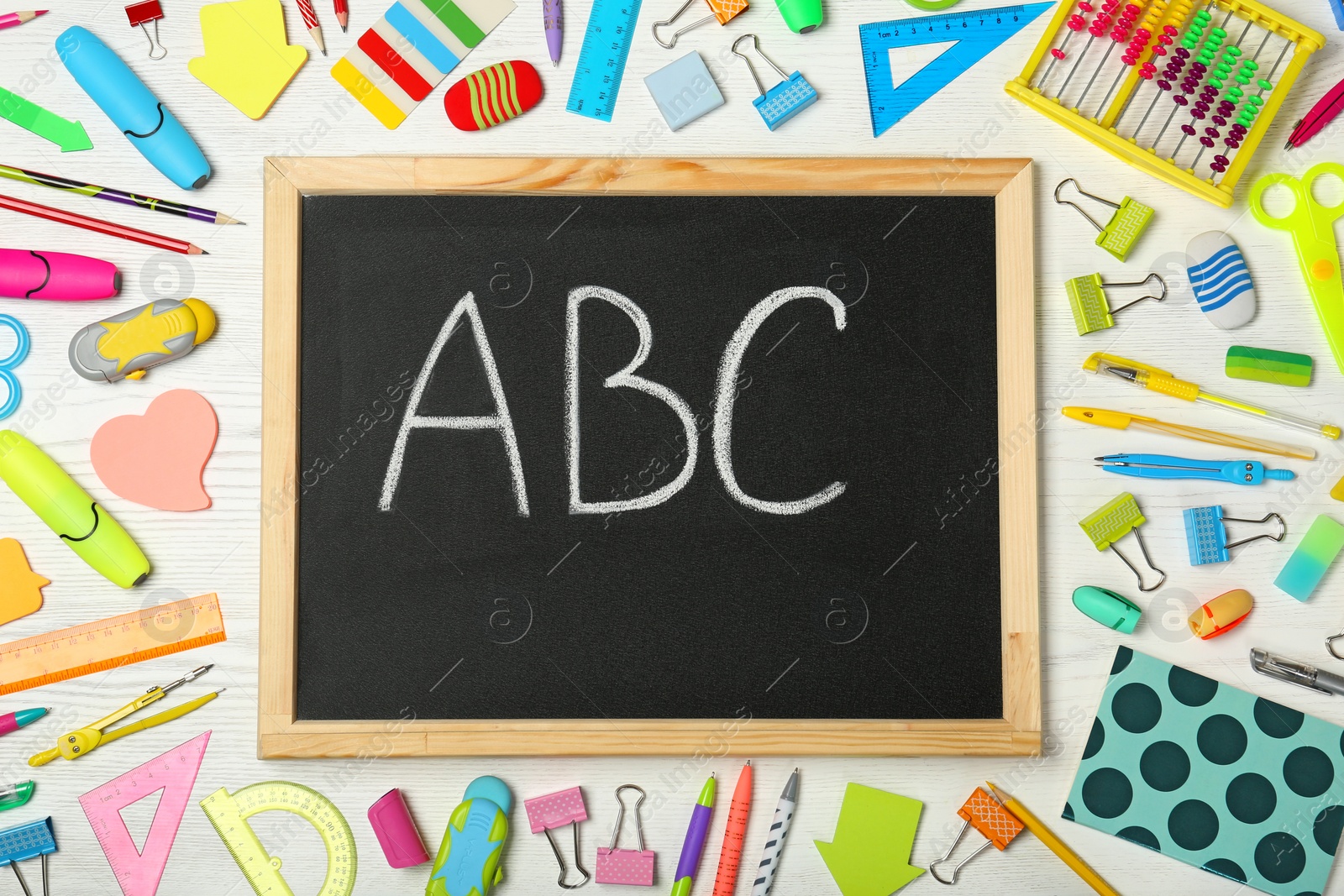 Photo of Flat lay composition with different school stationery and small chalkboard on wooden background