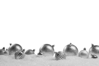 Beautiful silver Christmas balls on snow against white background