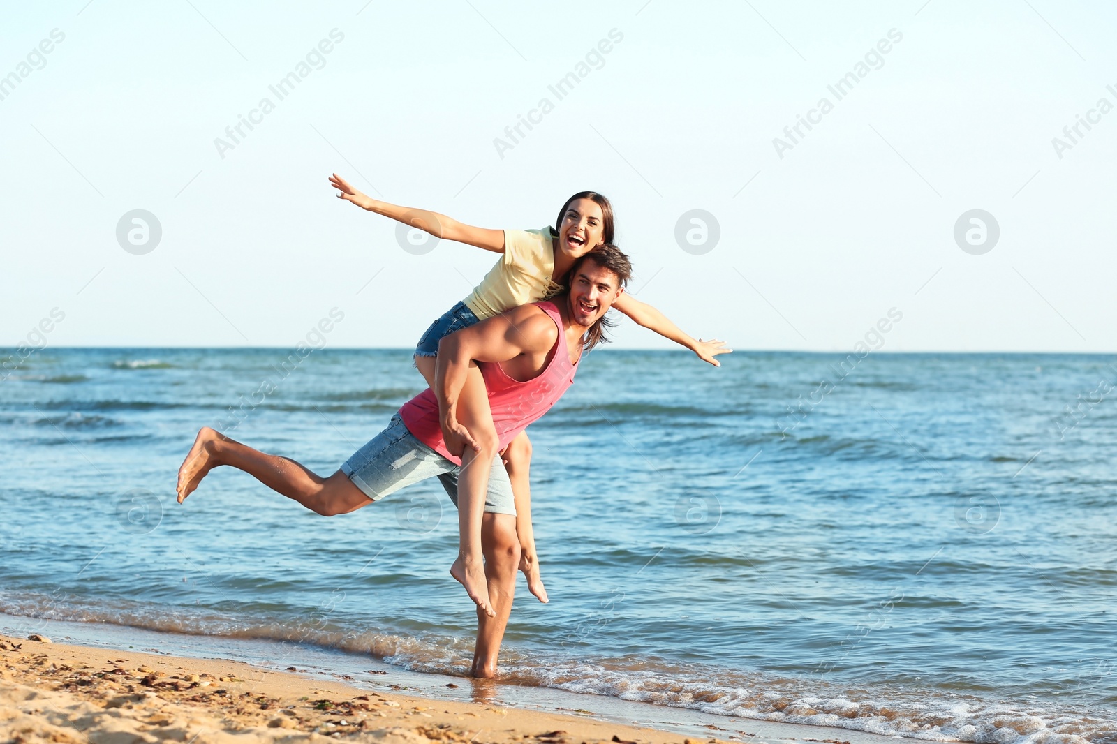 Photo of Happy young couple having fun at beach on sunny day